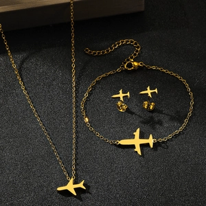 Détail d'un ensemble de bijoux avion dorés avec collier, bracelet et boucles d'oreilles