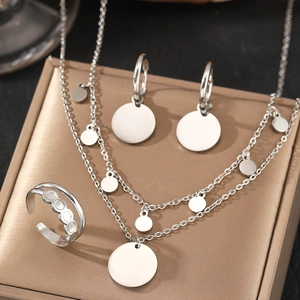Silver layered necklace set with round pendant earrings and open ring on gold display