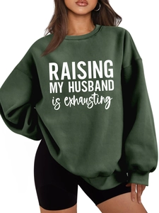 Detail of the white Raising My Husband text printed on a dark green casual sweatshirt