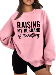Pink crewneck sweatshirt with 'RAISING MY HUSBAND' text and ribbed sleeve cuffs