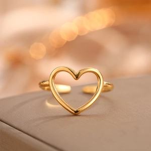 Macro shot of gold-plated heart-shaped open ring placed on a premium jewelry box