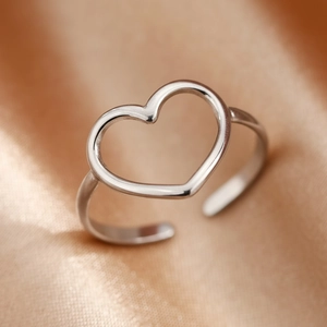 Adjustable stainless steel open heart ring in silver finish on champagne silk background