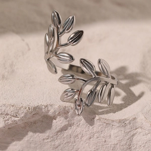 Minimalist silver leaf open ring made of stainless steel on white textured rock base