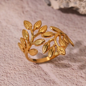 Detail of gold leaf and branch design on an adjustable stainless steel open ring