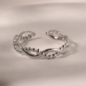 Details eines silbernen verstellbaren Rings mit Perlenverzierung und Flechtstruktur