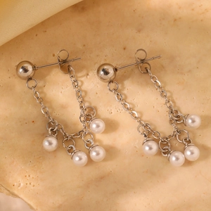 Elegant stainless steel tassel earrings featuring multi-layered pearls on a stone surface