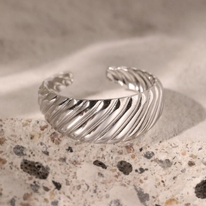 Bague croissant argentée réglable avec texture spirale sur fond de pierre naturelle