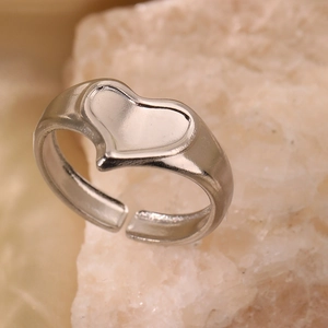Anello regolabile minimalista in argento con cuore concavo su sfondo di pietra naturale
