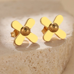 Gold clover flower earrings in stainless steel on a beige stone base for women