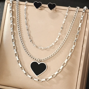Multi-layer silver heart necklace set with black enamel pendant and matching stud earrings