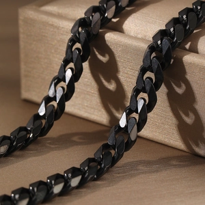 Men's polished black stainless steel Cuban link chain necklace on a luxury display box