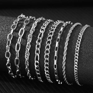 Variety of silver stainless steel chain bracelets displayed on a minimalist black cylinder