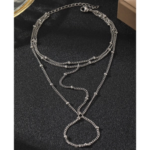 Layered silver bead chain bracelet and ring hand chain set for women on black texture