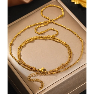 Elegant gold layered beaded necklace with lobster clasp and adjustable chain on a jewelry box