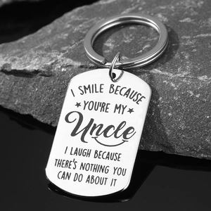 Polished stainless steel dog tag keychain with humorous engraved uncle quote on dark rock