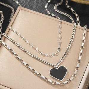 Collier à trois rangs argenté avec pendentif coeur noir sur un coffret à bijoux chic