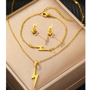 Flat lay of gold lightning bolt jewelry set featuring necklace, bracelet and earrings