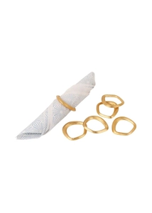 Detail view of irregular gold metal napkin rings with a matte finish on blue floral fabric