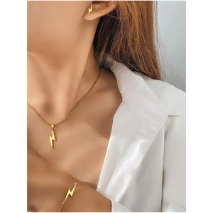 Golden lightning bolt jewelry set featuring a necklace, earrings, and bracelet on a model
