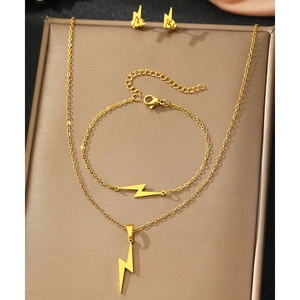 Golden lightning bolt jewelry set including necklace, bracelet and stud earrings on a tray