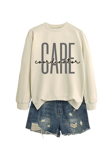 Flat lay of off-white oversized sweatshirt with CARE print and distressed denim shorts