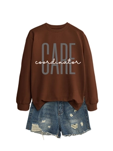 Detail of loose brown sweatshirt with CARE coordinator print and distressed denim shorts