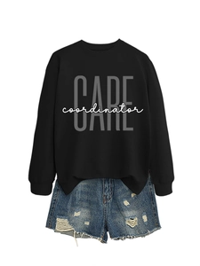 Detail of black crewneck sweatshirt with 'CARE coordinator' print and ripped denim shorts