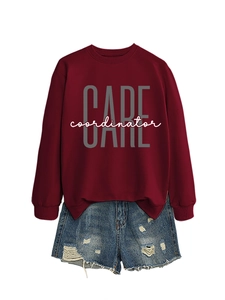 Close-up of a maroon pullover sweatshirt with CARE coordinator print and ripped denim shorts