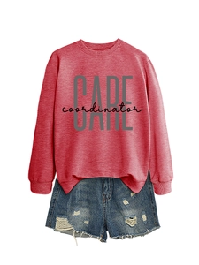 Detail of loose brick red crewneck sweatshirt with CARE coordinator print and denim shorts