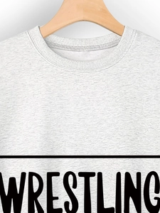 Close-up of light grey crew neck sweatshirt featuring bold black Wrestling print detail
