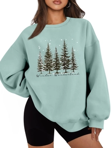 Close-up of mint green sweatshirt featuring pine tree print and Winter Wonderland text