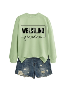 Detailed flat lay of a sage green crewneck sweatshirt with WRESTLING grandma graphic print