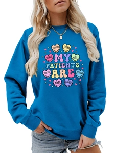 Detail of royal blue sweatshirt featuring colorful medical heart print and nurse quote
