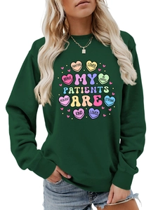 Close-up of heart graphics with brave kind strong text on dark green sweatshirt
