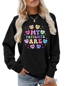 Close-up of black sweatshirt featuring heart graphics and MY PATIENTS ARE FIGHTERS print