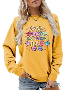 Detail of medical theme graphic print on mustard yellow crewneck sweatshirt