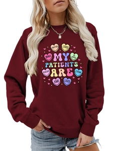 Detail of burgundy sweatshirt featuring heart graphic and inspirational text prints
