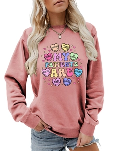 Detail of pink crewneck sweatshirt featuring colorful My Patients Are heart graphic
