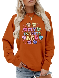 Close-up of orange sweatshirt with vintage medical theme print and heart graphics