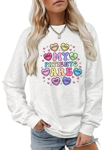 Detail of white crewneck sweatshirt with colorful My Patients Are heart graphic