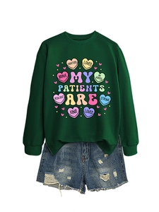Detail of dark green crewneck sweatshirt with heart graphics and ripped denim shorts