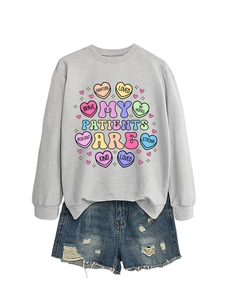 Flat lay of gray long-sleeve sweatshirt with colorful heart and denim shorts set