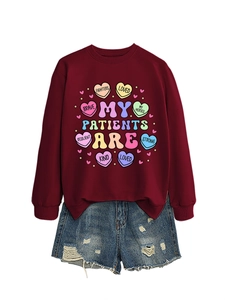 Flat lay of burgundy crewneck sweatshirt with heart graphics and distressed denim shorts