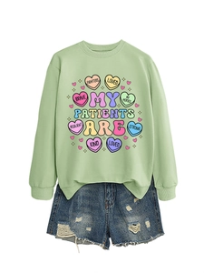Detailed shot of mint green sweatshirt with medical theme hearts and denim shorts
