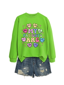 Flat lay of bright green crewneck sweatshirt with illustration and distressed denim shorts