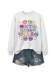 Flat lay of gray sweatshirt with medical theme graphics and distressed denim shorts