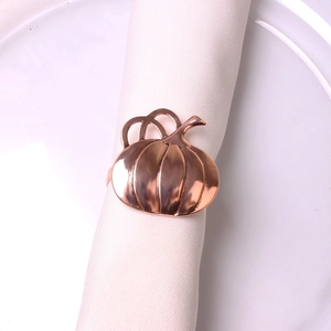 Detail showing a rose gold pumpkin napkin ring with polished finish on a white napkin