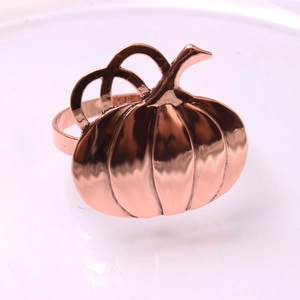 Detailed close-up of rose gold pumpkin napkin ring with smooth metal finish and rib textures