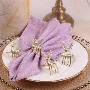 Set of 4 matte gold reindeer napkin rings on purple linens for holiday table decor