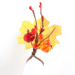 Detail of autumn napkin ring with maple leaf, orange berries and mini pumpkin